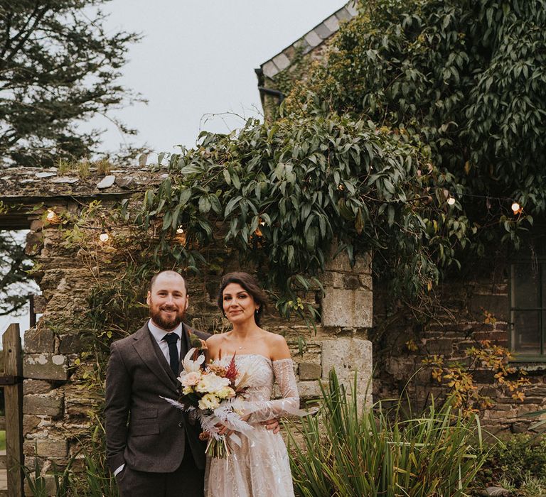 Bride and groom stand close together and pose after their rustic style wedding ceremony