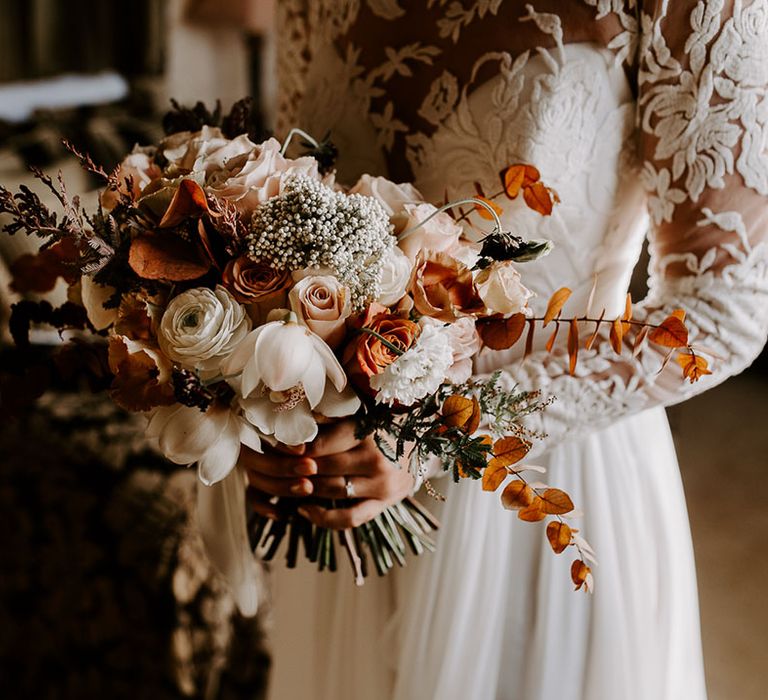 Orange, white and pink wedding bouquet held by bride