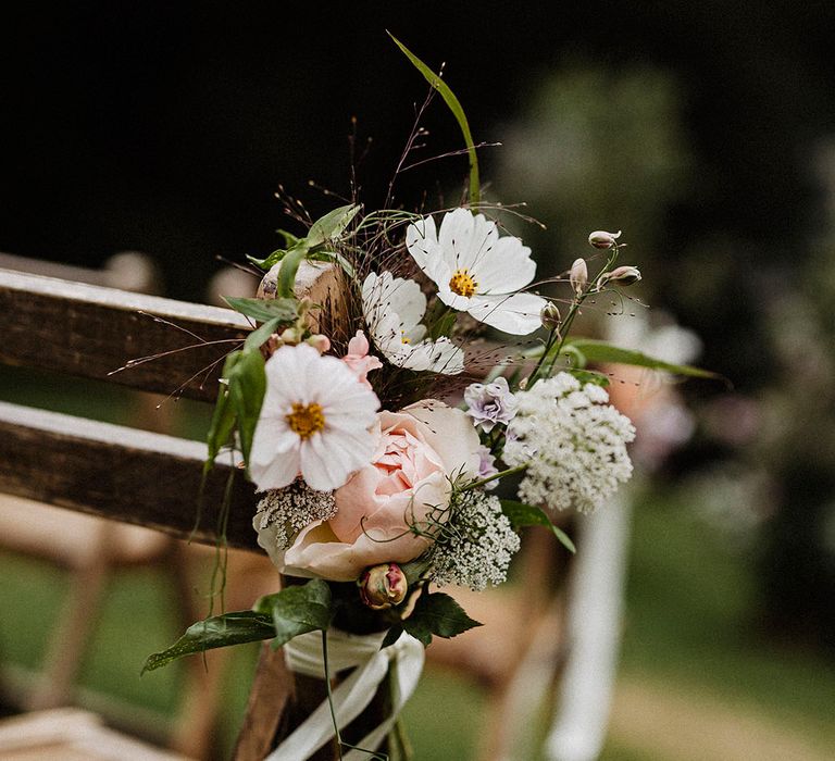 Aisle decoration with white flowers including cosmos and pink roses 