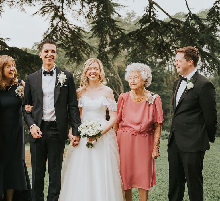 Bride and groom with family members for classic country house wedding 