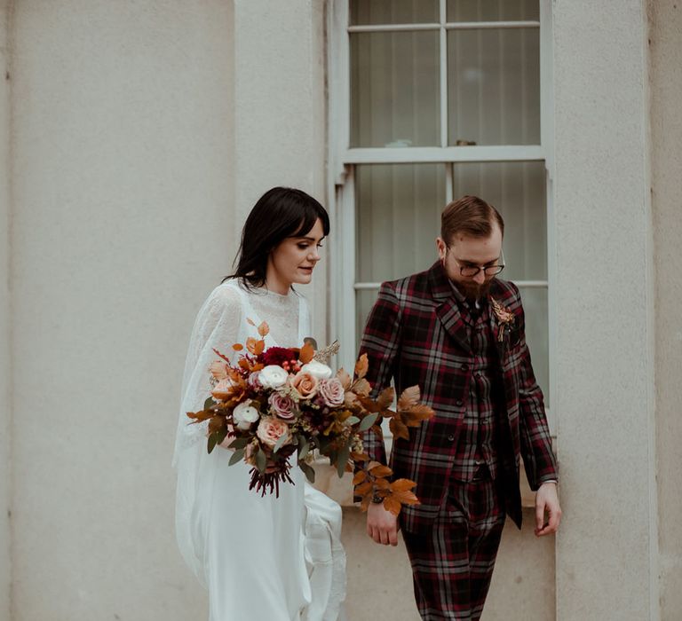 Bride & groom walk together on their wedding day as bride wears Gucci gold heeled sandals and groom wears vintage Dr Martens