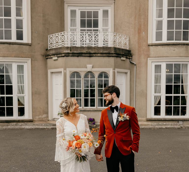 Bride and groom smile at each other as they stand outside their wedding venue, Gracehall 