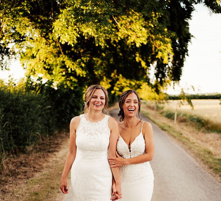 Brides walk holding hands on their wedding day 