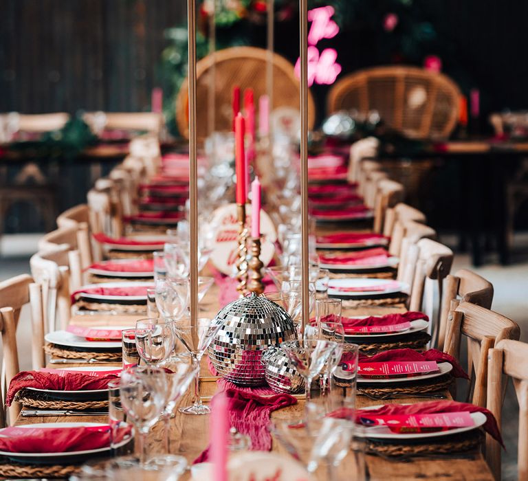 Pink and red wedding tablescape with disco ball decor and tall tropical flower centrepieces 