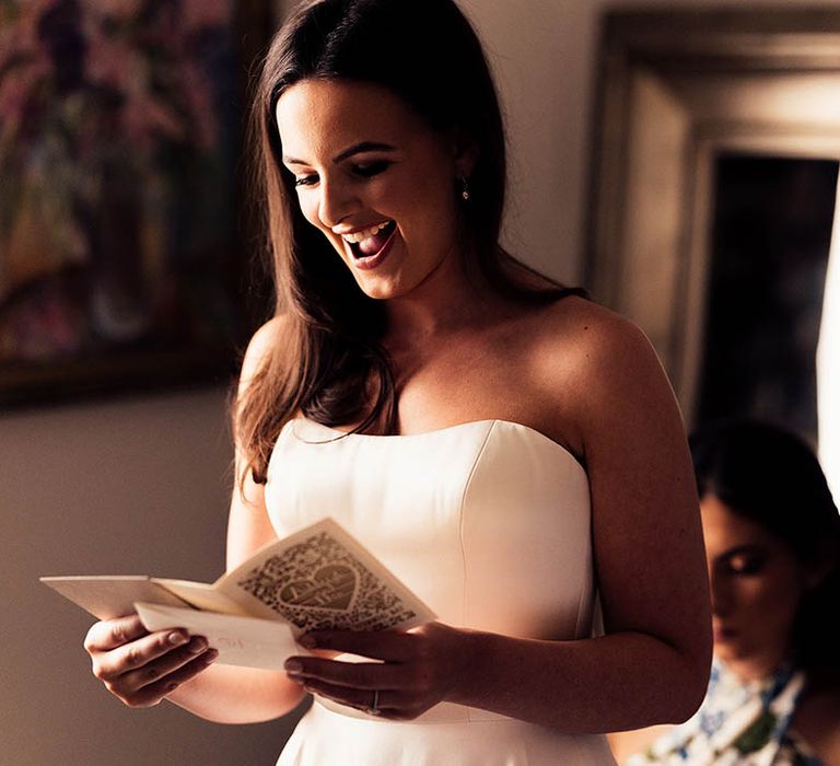 Bride reads a personal letter on the morning of her wedding as she gets ready 