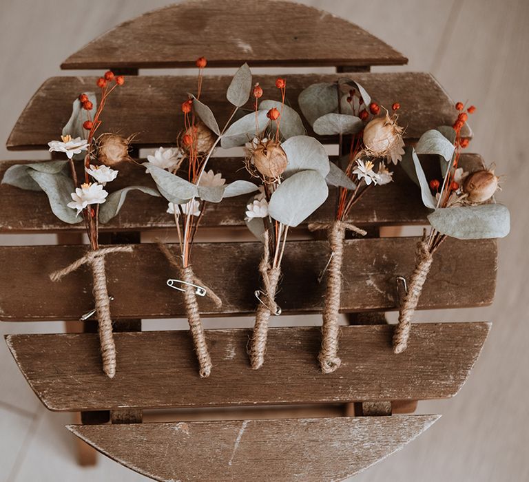 Dried floral buttonholes tied with brown string 