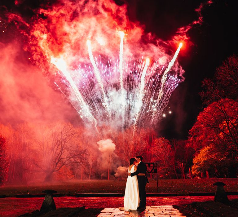 The bride and groom share a special moment alone together and kiss as the fireworks go off 