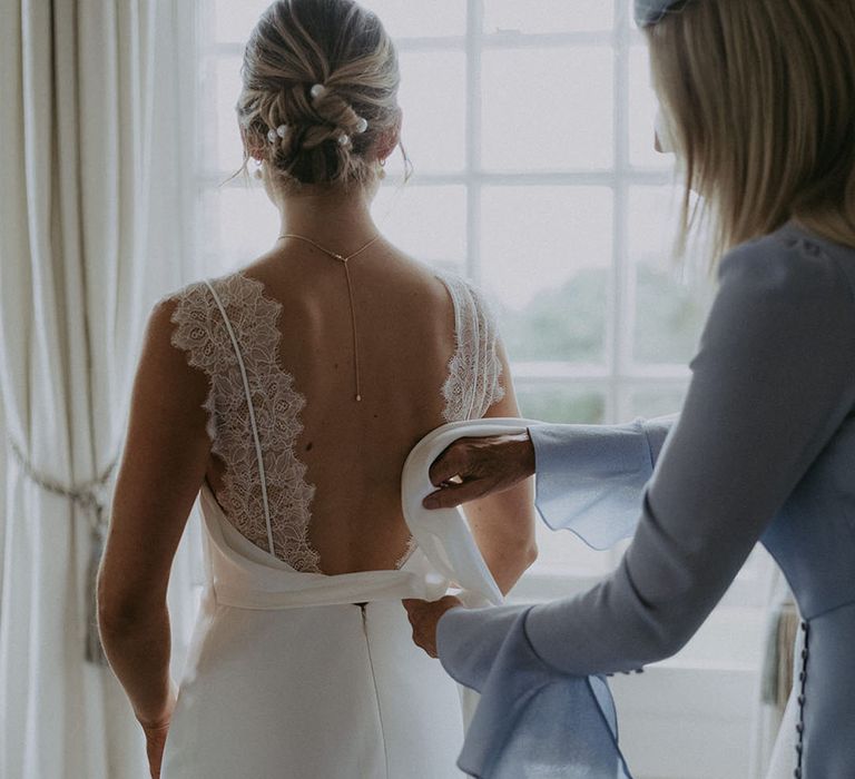 Wedding guest does up bow to the back of Savannah Miller wedding dress