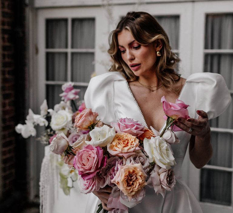 Bride hiding rose wedding bouquet in different tones and shades 