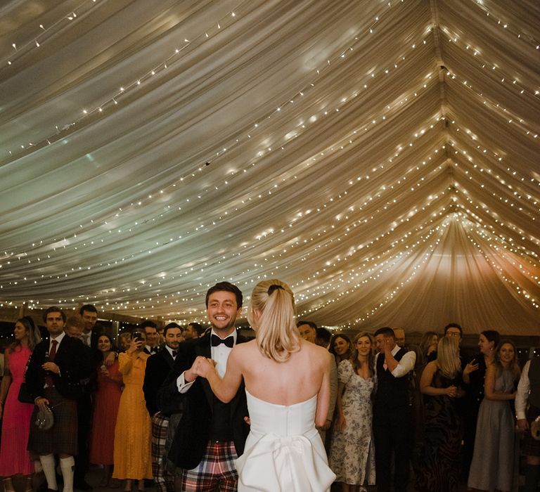 The bride an groom have their first dance in the marquee reception together at The Cowshed Crail 