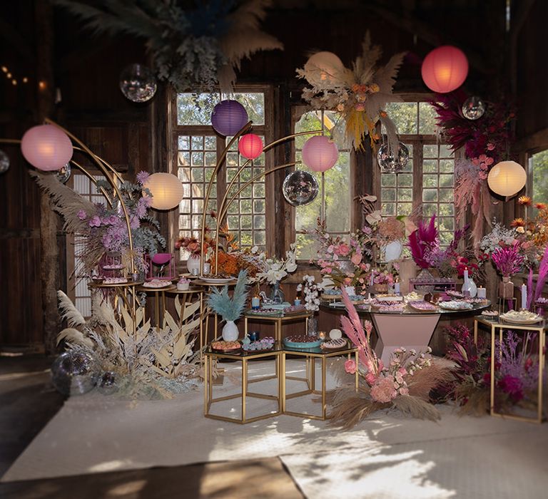 Colourful paper lanterns decorating a wedding dessert station with pastel dried wedding flowers and more 