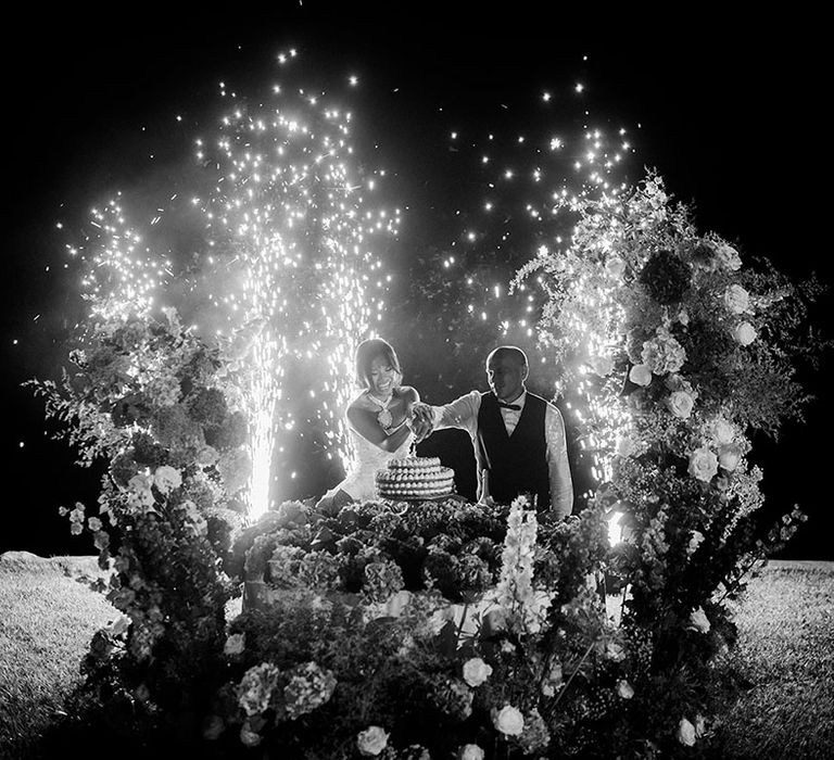 Sparklers erupt as the bride and groom cut into their Italian wedding cake