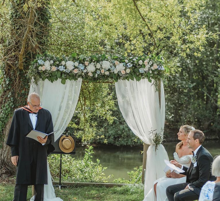 White rose flower altar decoration with white drapery for outdoor wedding ceremony at chateau in France 