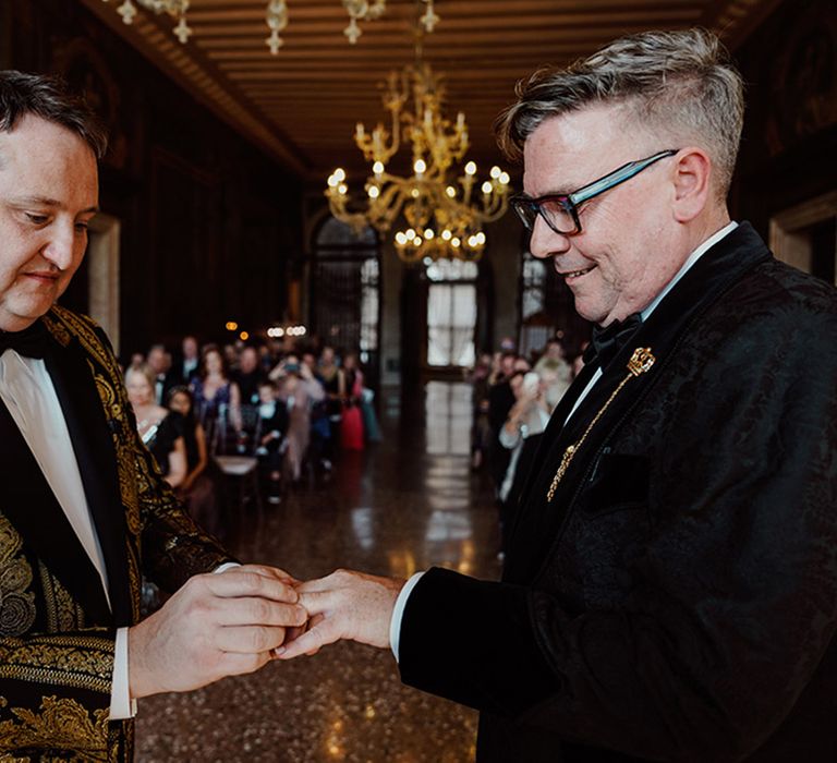 Grooms exchange rings at their same sex wedding ceremony 