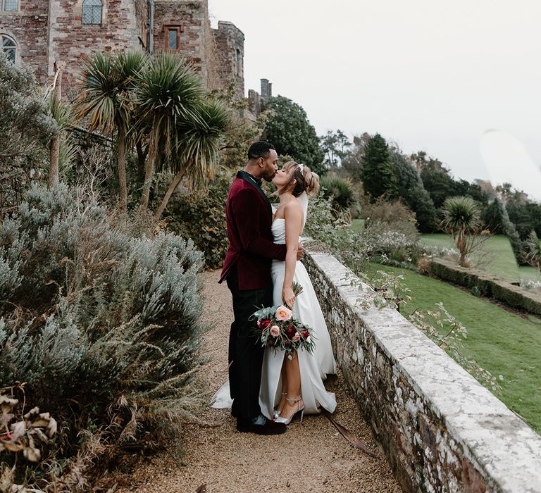 The bride and groom take a stroll together as they walk around Berkeley Castle wedding venue in the Cotswolds 