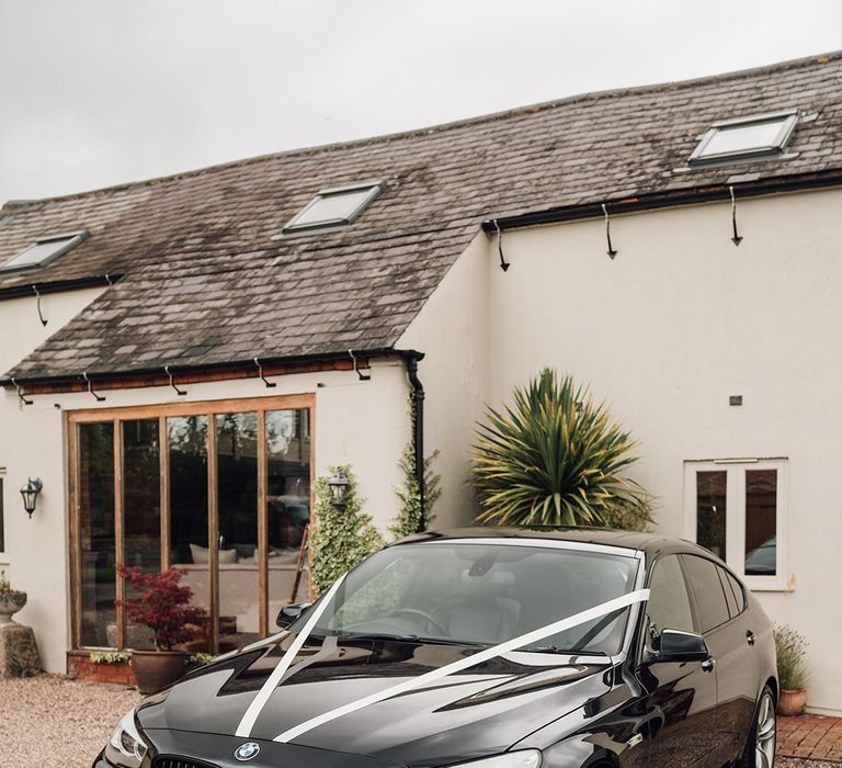 Black wedding car with white ribbon decoration 