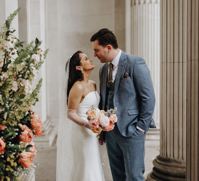 Classic and timeless city wedding with the bride in a stunning strapless wedding dress and groom in light blue wedding suit 