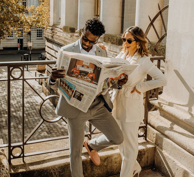 Bride and groom casually reading the newspaper at their intimate elopement 