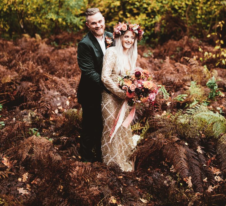 Bride and groom laughing in woodland shoot. Bride wears oversized flower crown. Photography by Maryanne Weddings.