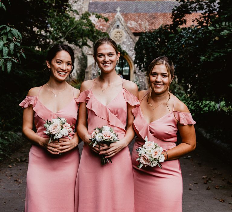 Bridesmaids in pink satin bridesmaids dresses 