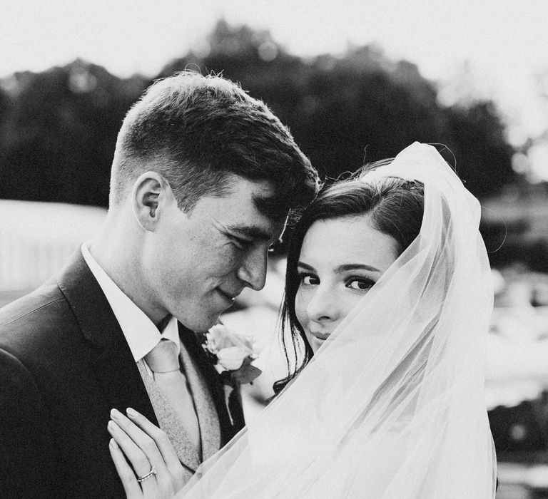 Bride & groom with veil blowing in the wind 