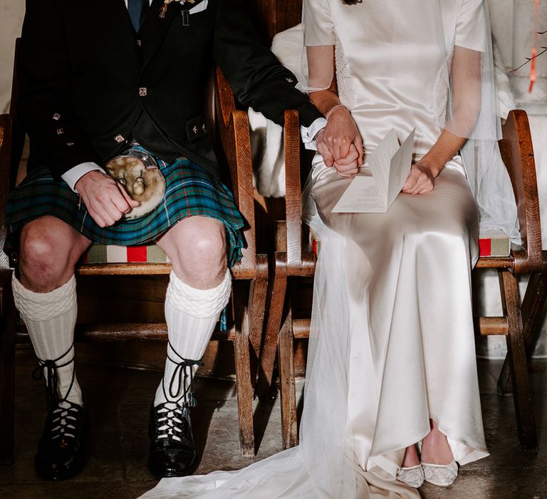 Bride and groom sit down at church wedding ceremony