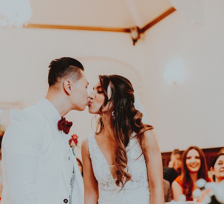 Bride & groom kiss during wedding ceremony