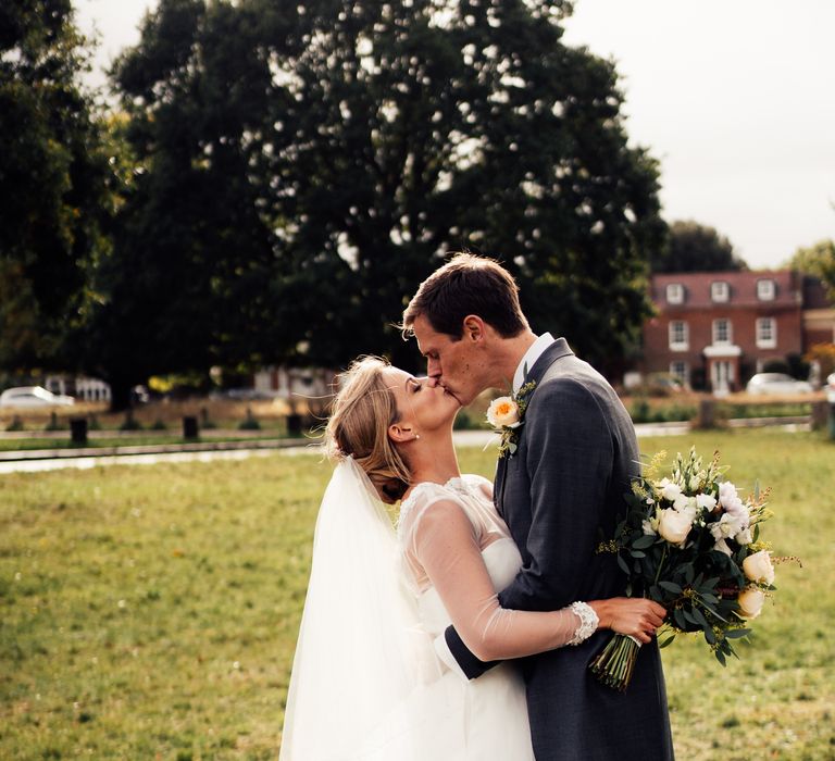 Bride & groom kiss outdoors on the morning of their wedding