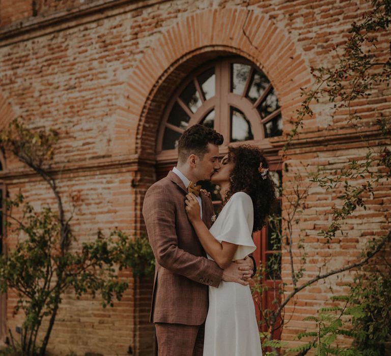 Bride and groom kissing on the grounds of Château de Caumont 