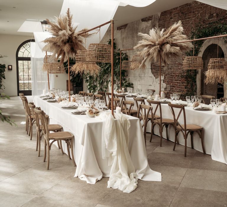 Wedding reception with pampas grass installation and wicker lampshades