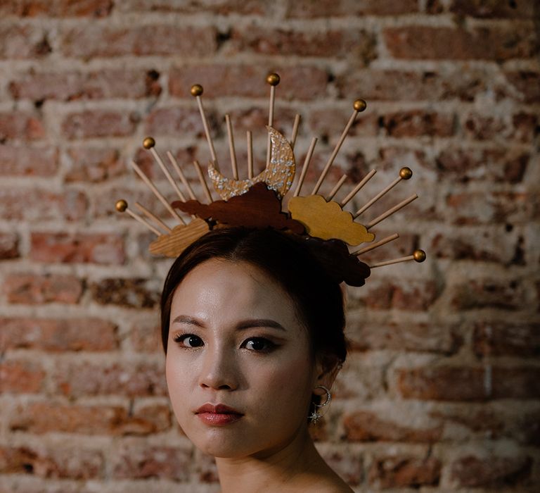 Beautiful Asian bride in a moon and clouds headdress with shimmering eyeshadow