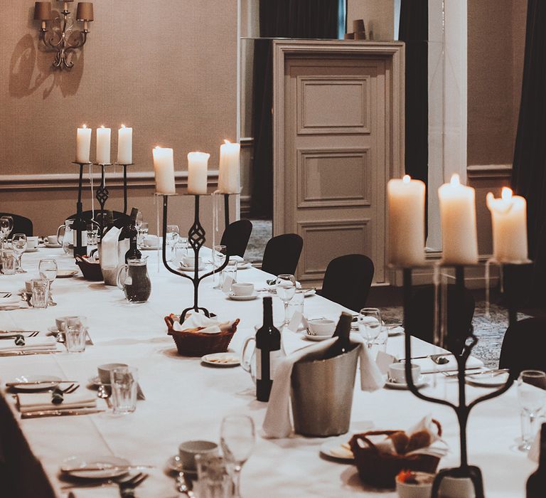 Intimate wedding reception with black candelabras and pillar candles 