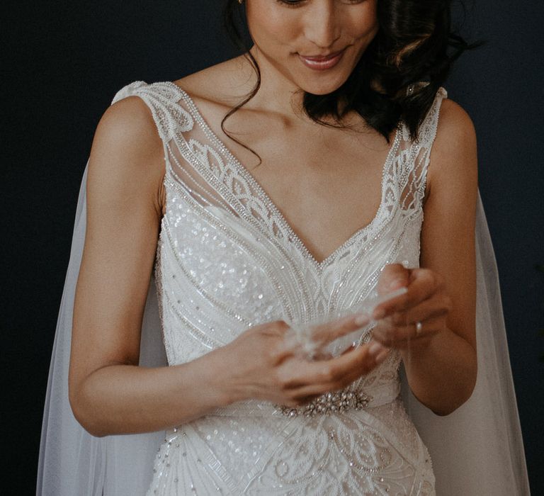 Bride wearing Eliza Jane Howell wedding dress with embroidered beads and sequins, and a veil cape 