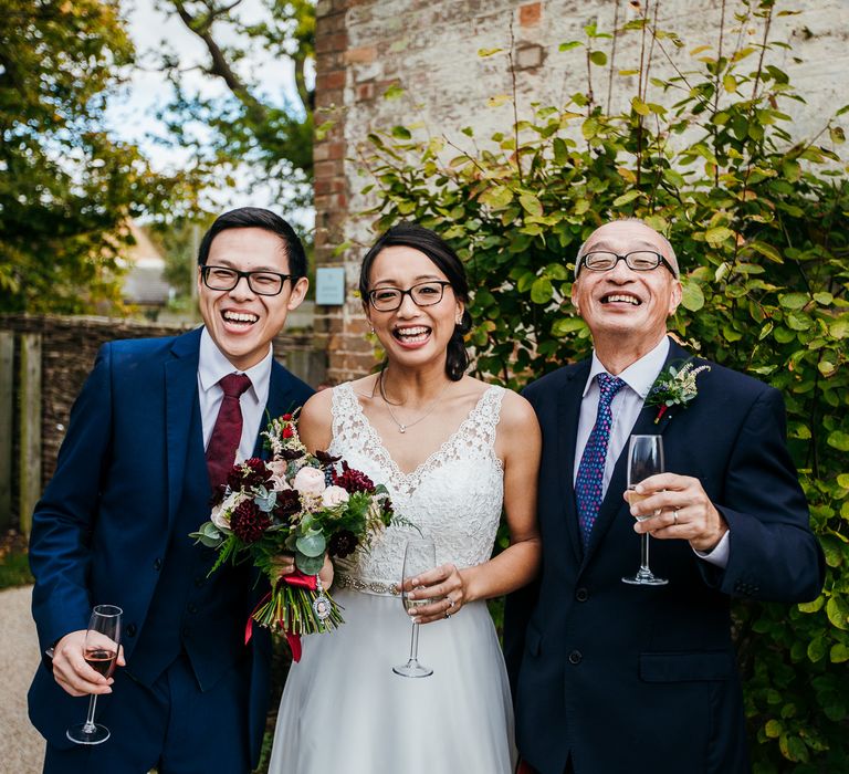 Bride & groom smile with father of the bride on wedding day