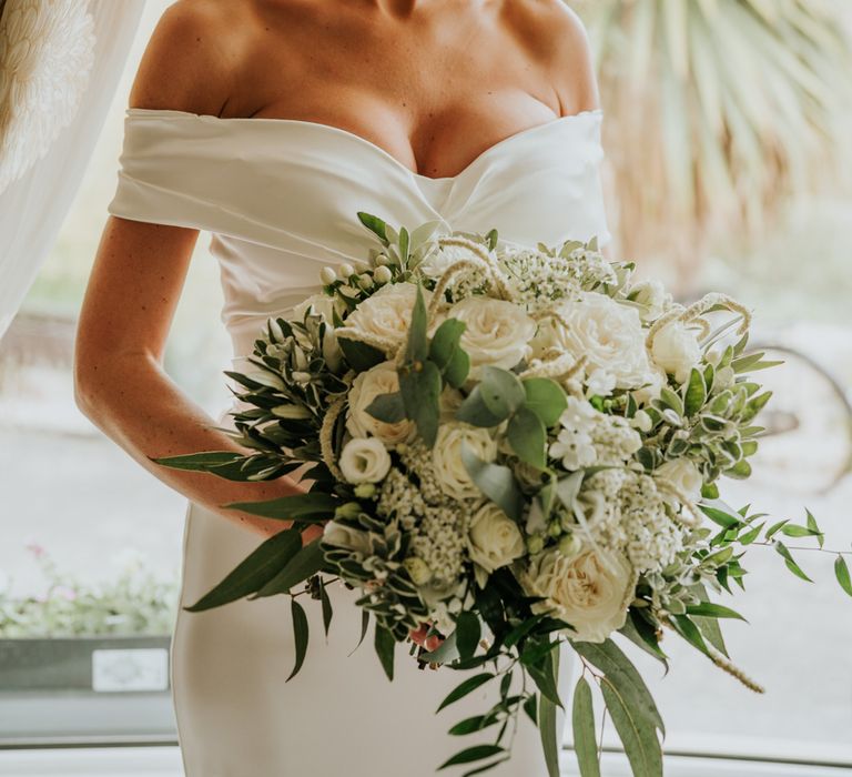 Bridal bun with veil and white flower bouquet