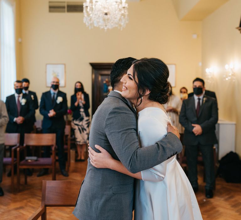 Bride & groom hug during civil ceremony at the Chelsea Old Town Hall on their wedding day