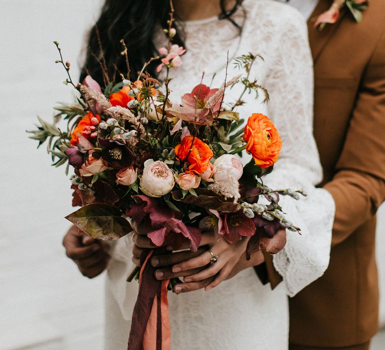 Orange and pink wedding bouquet with deep red foliage 