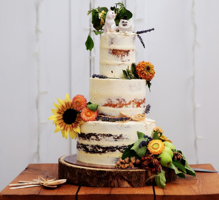 Naked wedding cake complete with brightly coloured flowers as decoration 