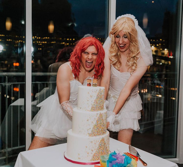 Grooms wearing drag cut their Hummingbird Bakery wedding cake | Kim Williams Weddings