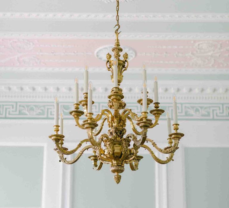 Botley's Mansion reception room with pale green and pink decor and grand chandelier 