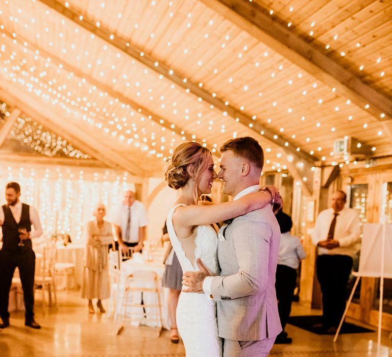 Bride and groom dance under fairy lights at Chycara venue in Cornwall