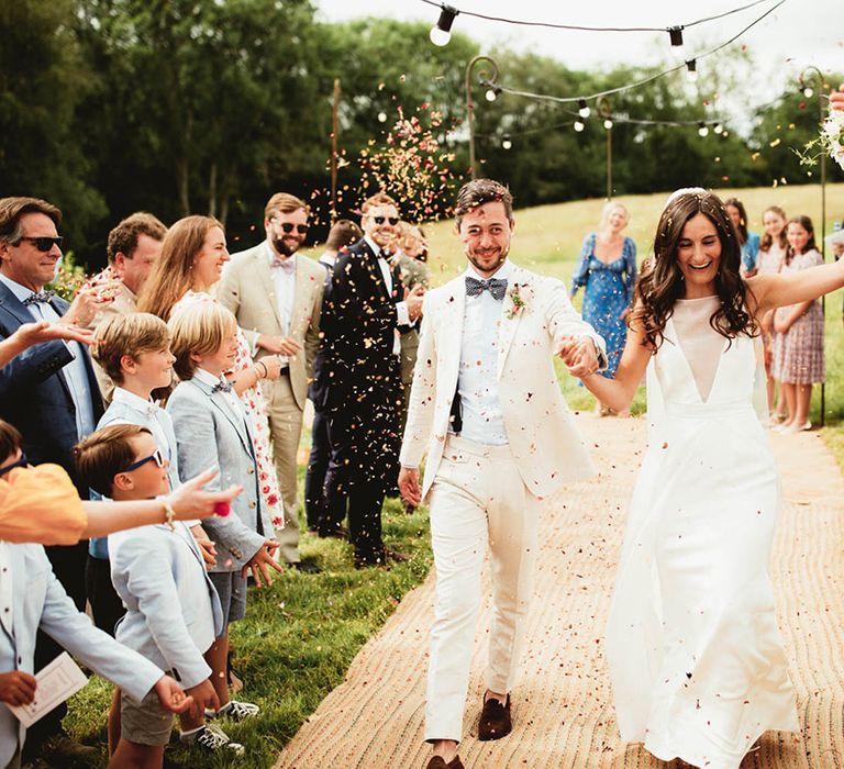 Bride & groom walk down the aisle on their wedding day outdoors