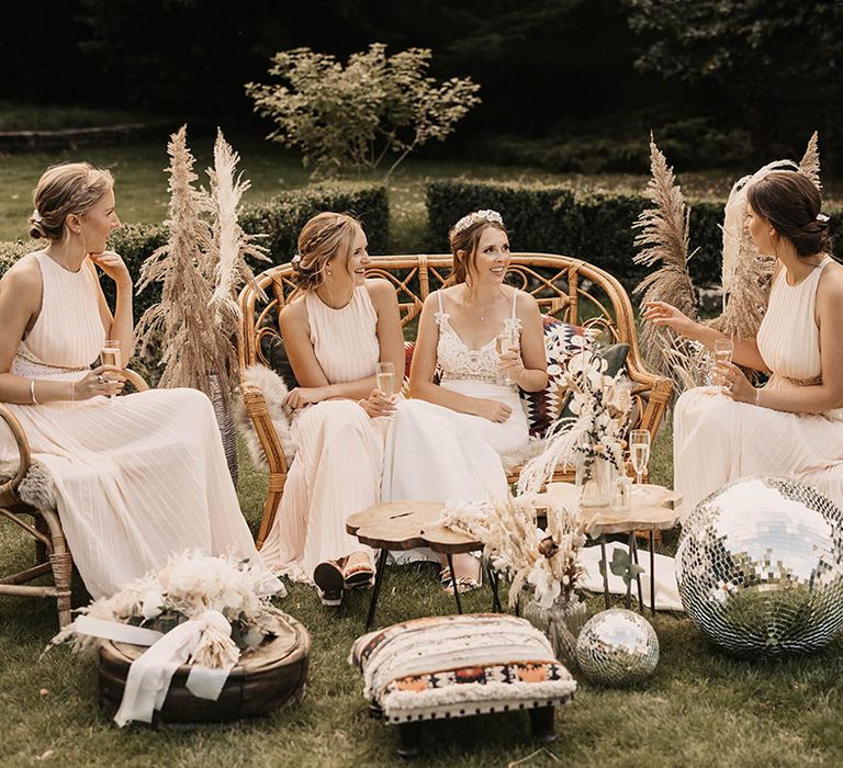 Bride sits outside with her bridesmaids on her wedding day