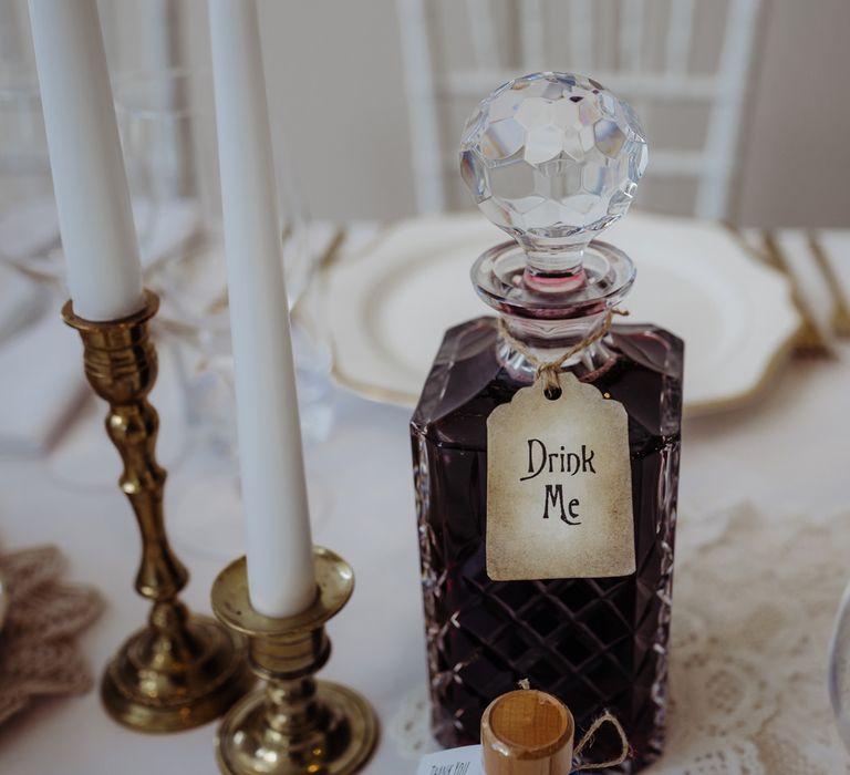 Crystal cut decanter of red wine with 'Drink Me' label for rustic chic wedding reception