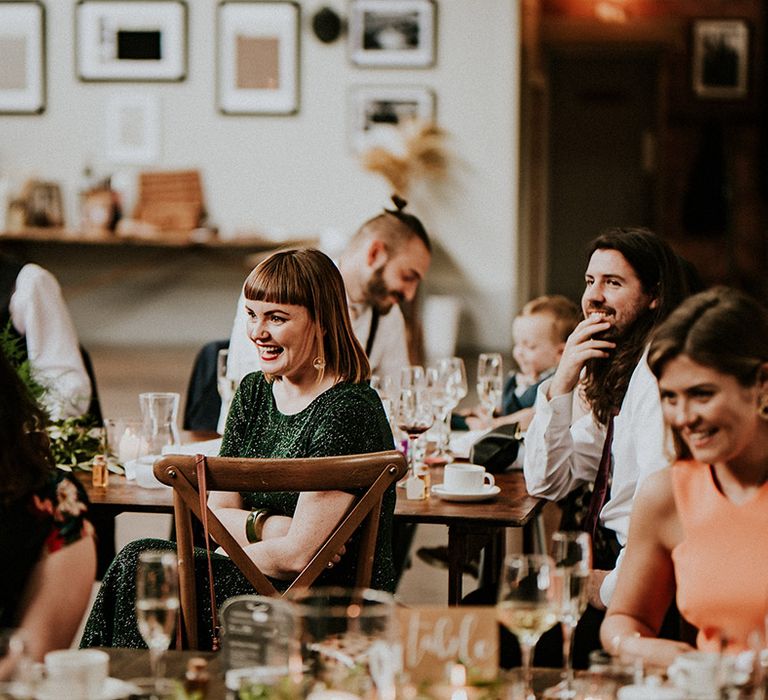 Wedding guests laugh during reception