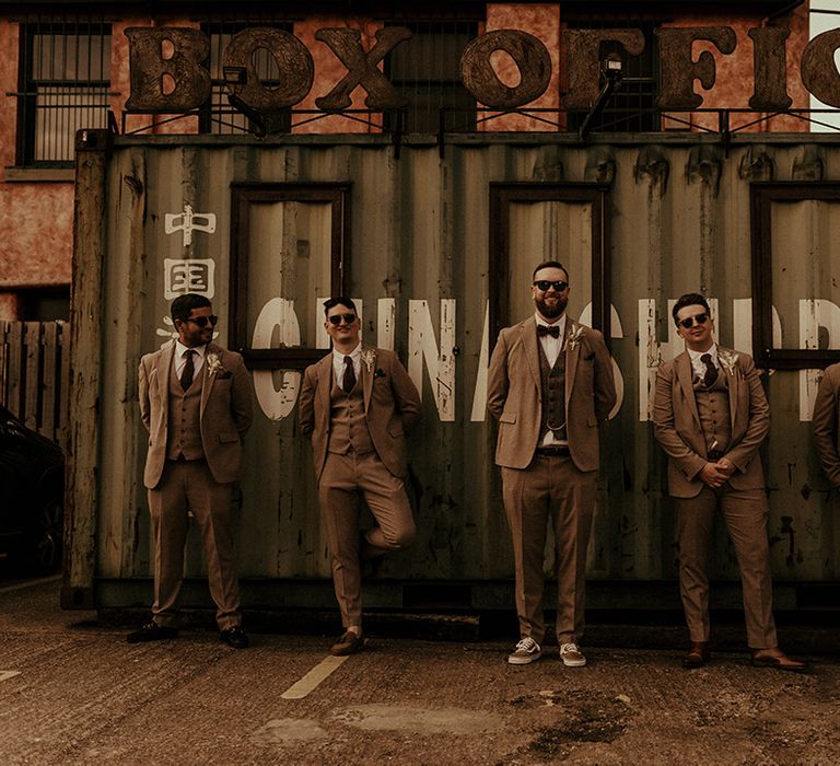 Groomsmen in three-piece tweed suits, bow ties and trainers at industrial Victoria Warehouse wedding 