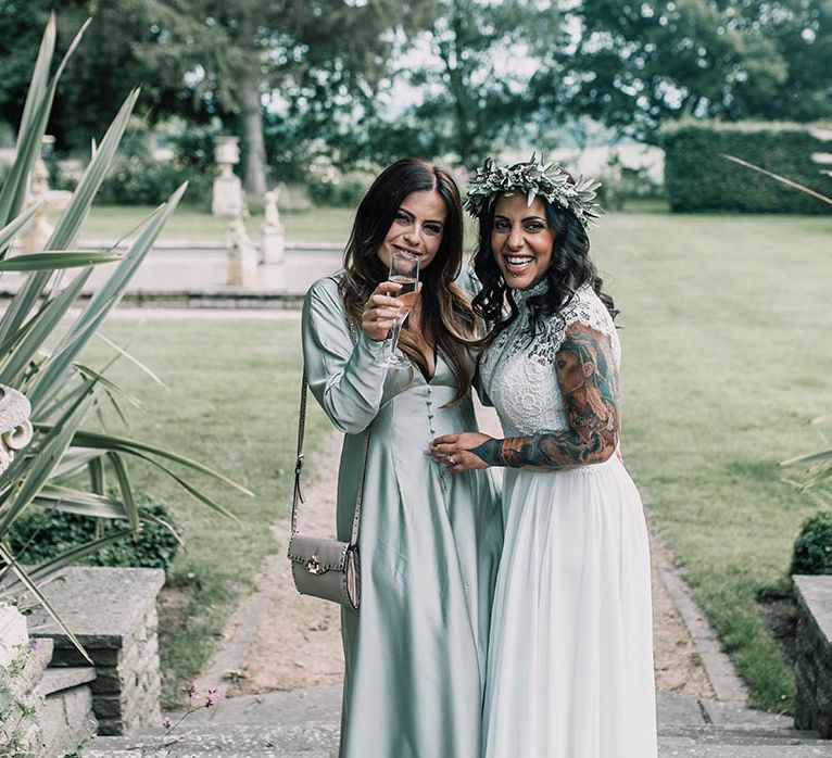 Bride wears floral crown on her wedding day and stands with guest