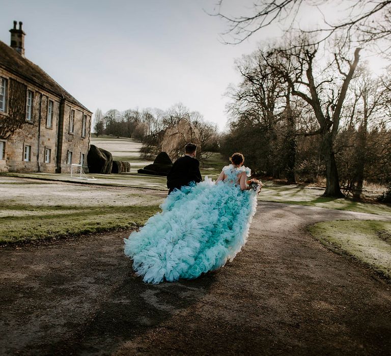 Bride in a Millia London light blue wedding dress with long ruffle train at Newburgh Priory in Yorkshire