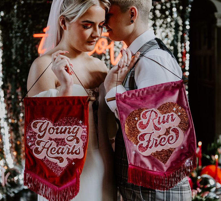 Deep pink and red velvet banners with retro font and glitter saying young hearts run free