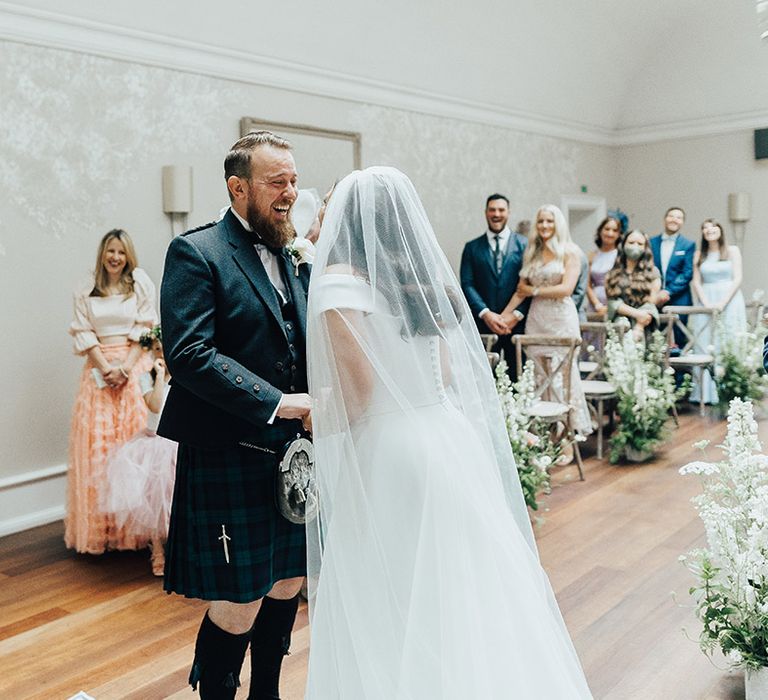 Luxury English micro wedding with groom in a tartan kilt and bride in a Suzanne Neville wedding dress and chapel veil 